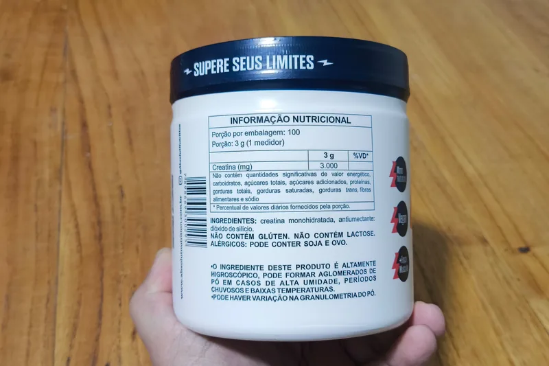 Verso do pote Absolut Nutrition com tabela nutricional de porção de 3 g e lista de ingredientes: creatina monohidratada e antiumectante dióxido de silício